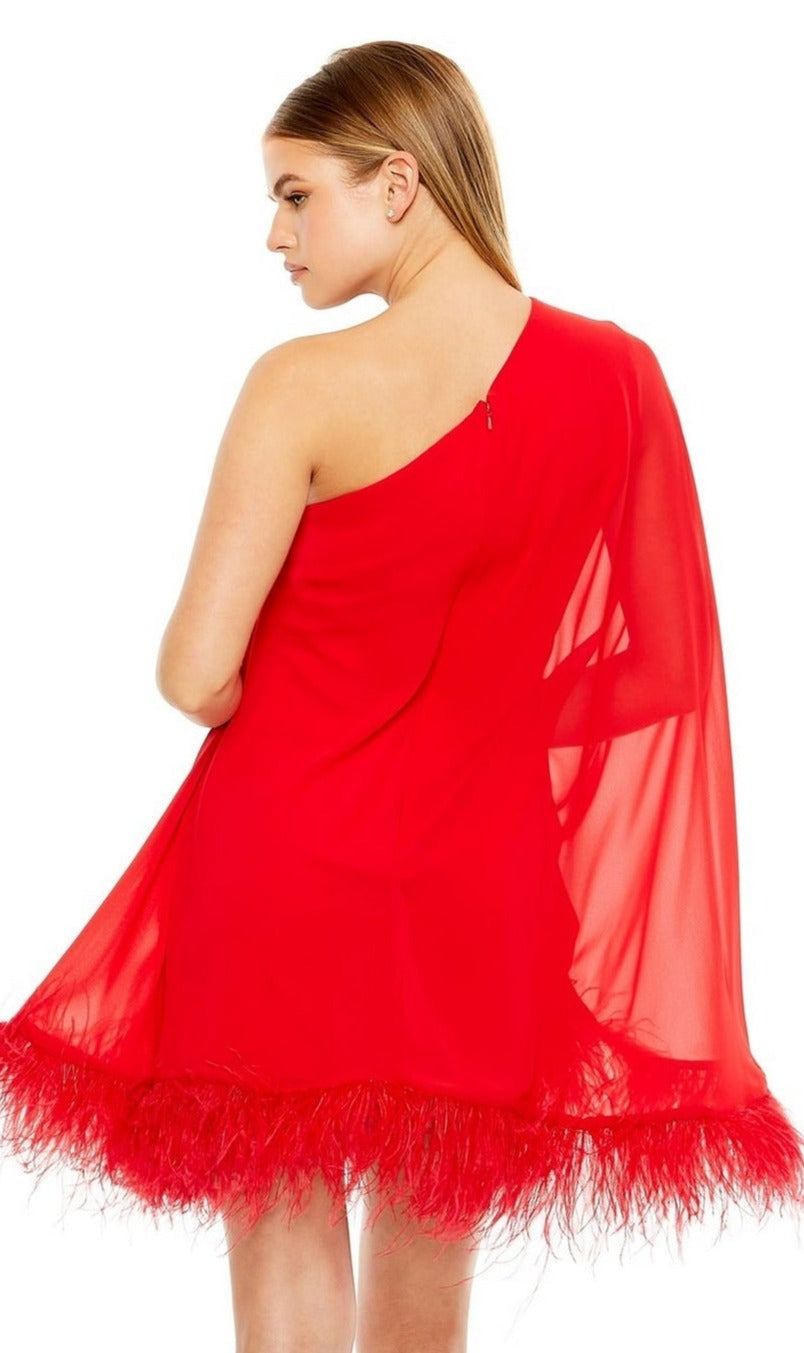 A woman wears the Mac Duggal 11623 Short Wedding Guest Dress, a bright red one-shoulder style with sheer fabric and a feather-trimmed hem, standing with her back slightly turned.